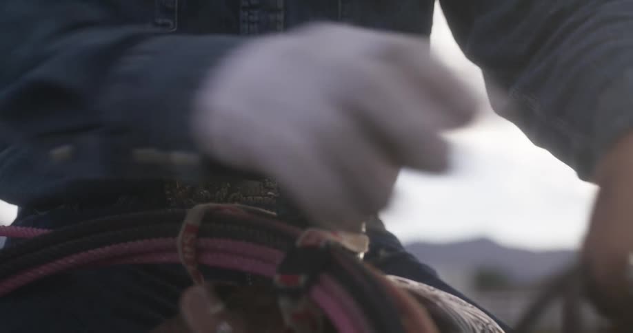 A man buckling up his horse