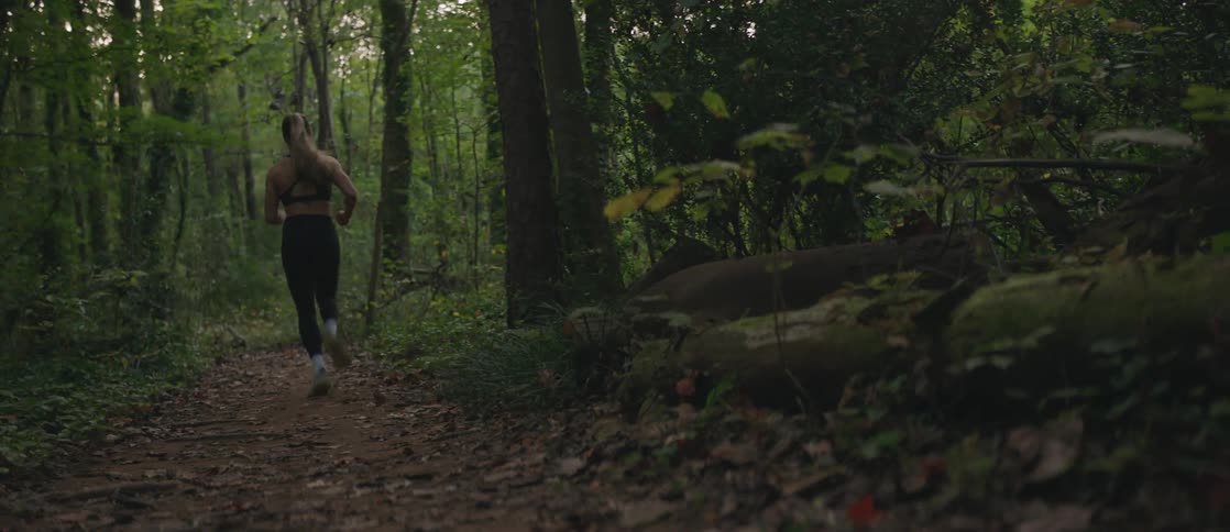 Woman running backward in a forest