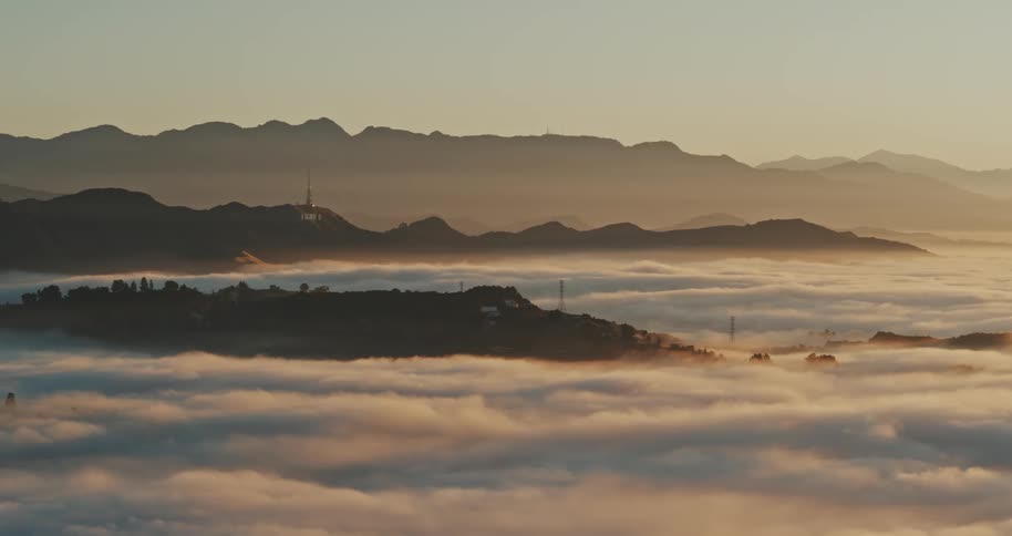 Golden clouds and fog blanket the Hollywood Hills up above Los Angeles