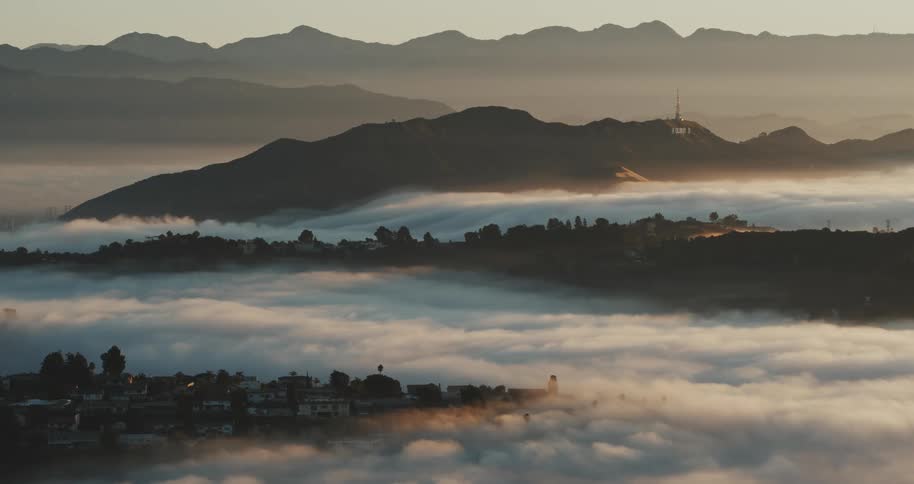 A river of clouds and mist float through the Hollywood Hills at dawn, with the Hollywood sign in the background