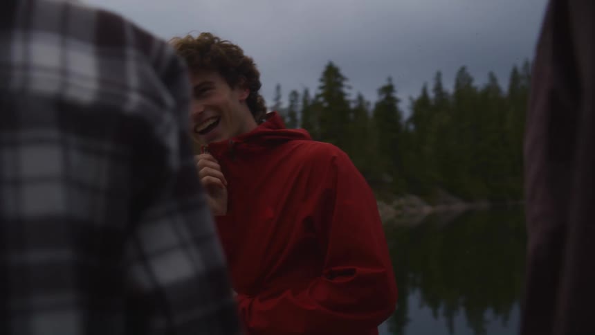 Friends talking by a lake under a cloudy sky