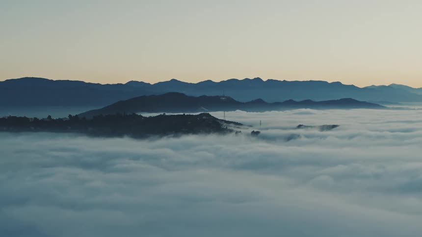 Aerial view of clouds above mountain level in a morning sky