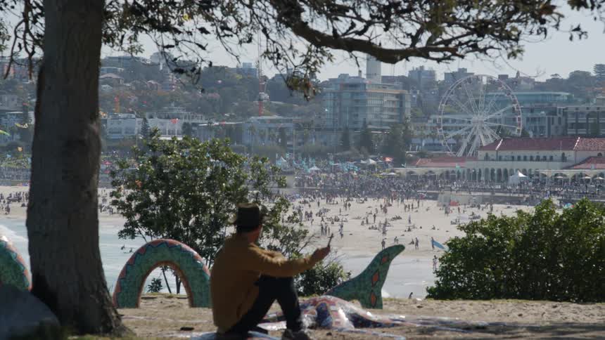 A man sitting talking on his cell phone watching the beach