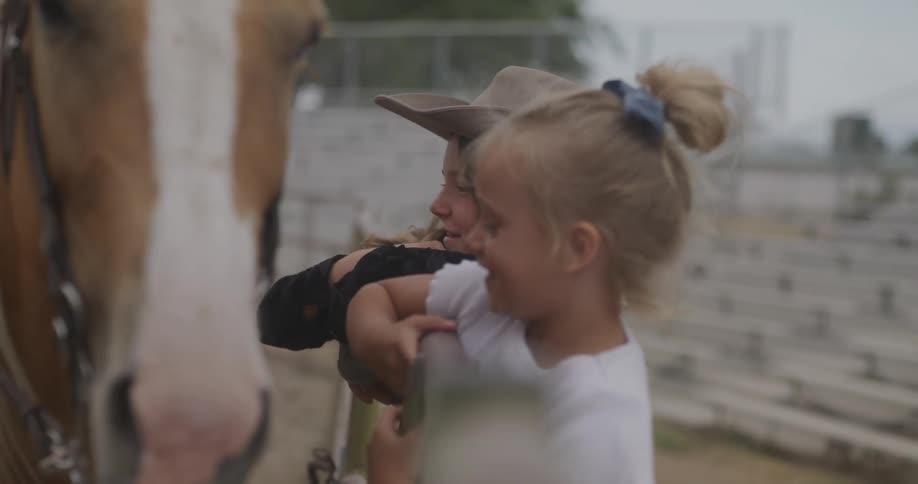 Two girls have fun next to a horse in the rodeo