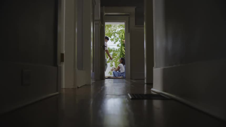 Two people talking sitting at the door of their house