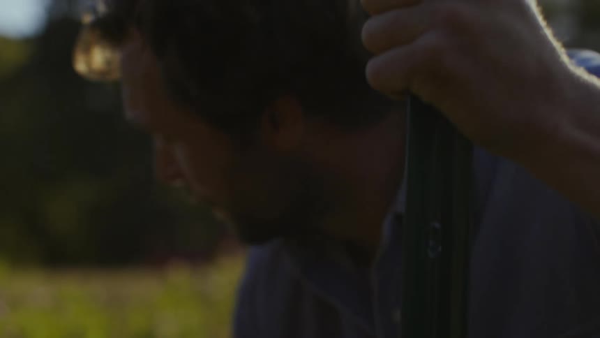 Portrait of a hard working farmer building fence in an outdoor natural environment