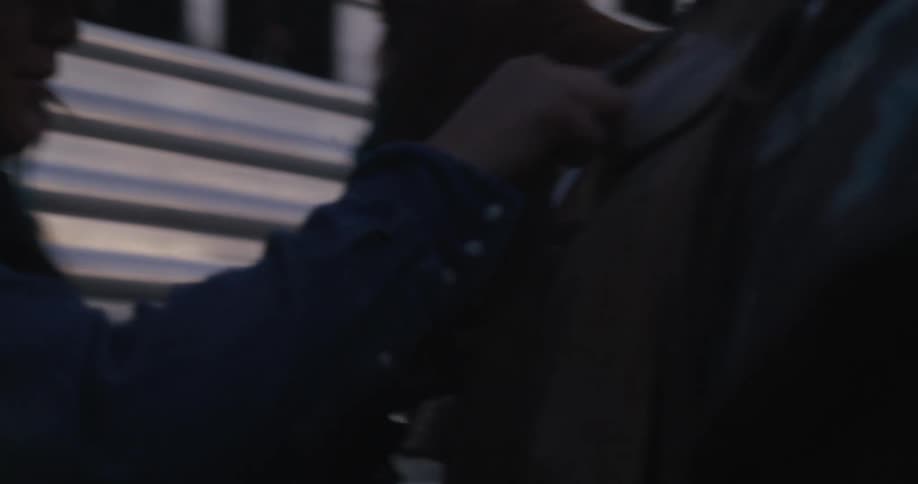 Cowgirl tightening the saddle straps on her horse