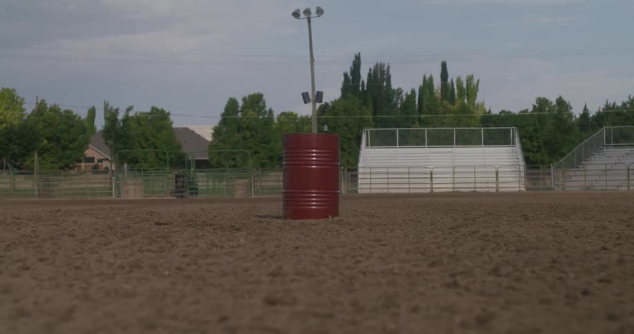 A red barrel in a dirt arena during the morning