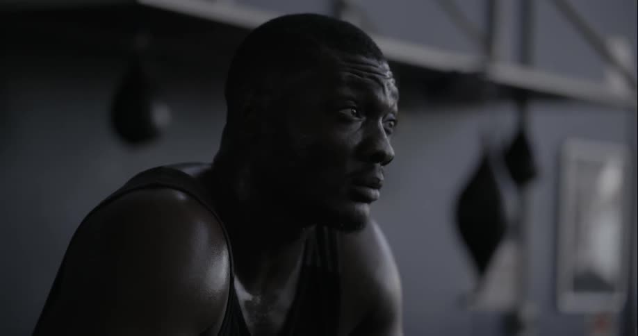 A man is sitting down in a gym