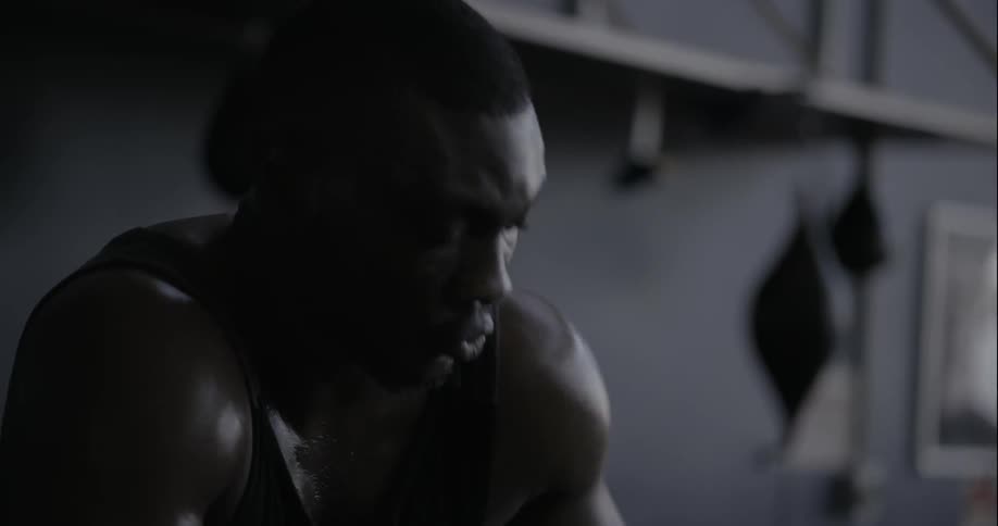Man gets up off a bench at a gym