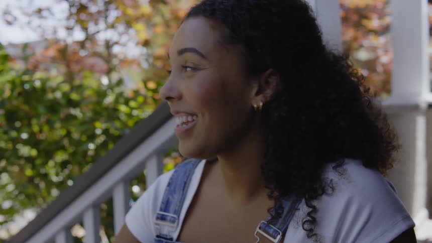Woman talking to friends in the porch drinks a soda