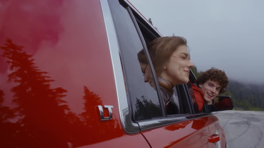 A boy and a girl in a car window while traveling