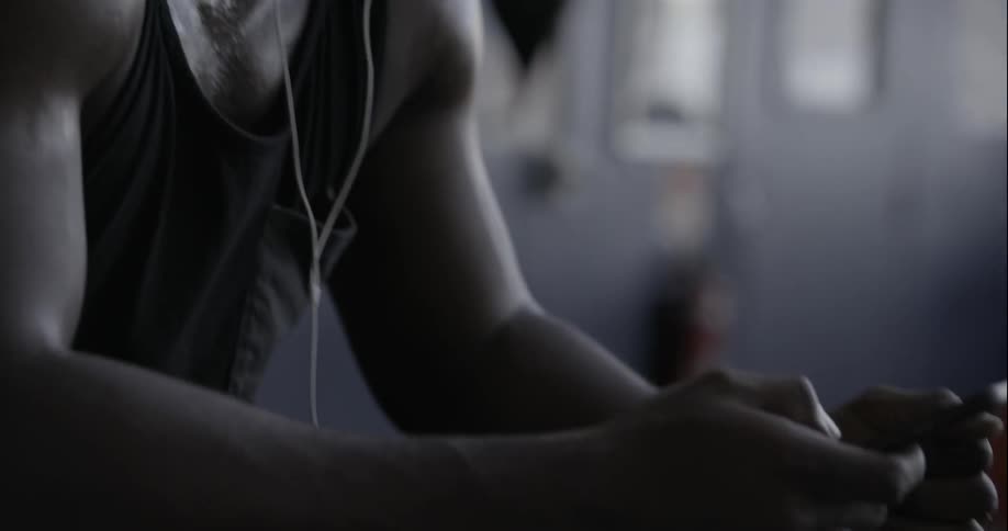 Man wearing earphones looks at his phone