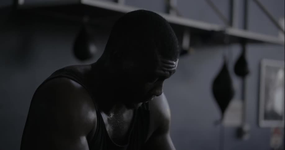 Athlete taking a deep breath before getting up to continue his work out