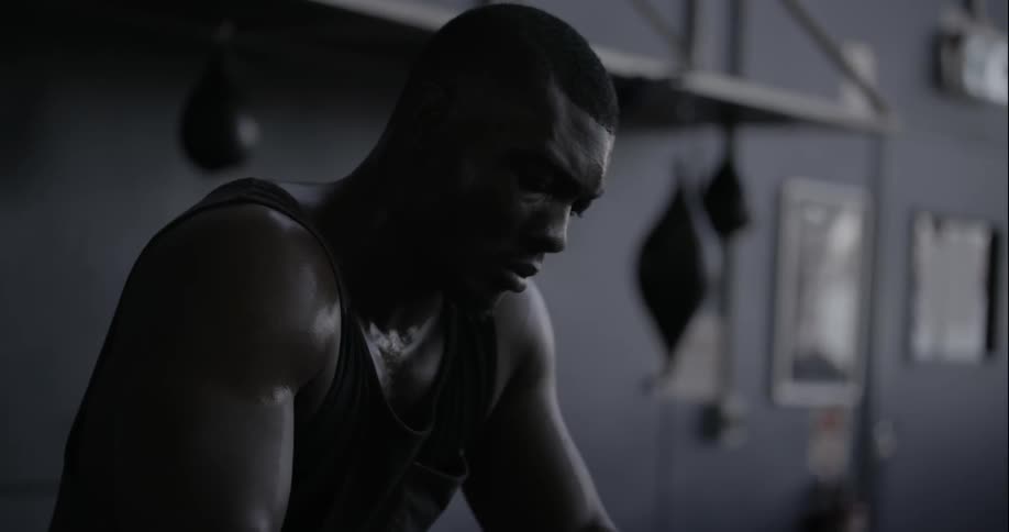 A man is unwrapping his hands in a gym