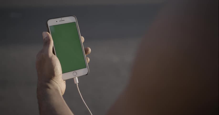 Someone looking at their smartphone as traffic passes by