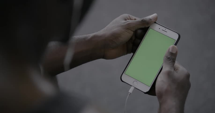 A man is looking down at a phone