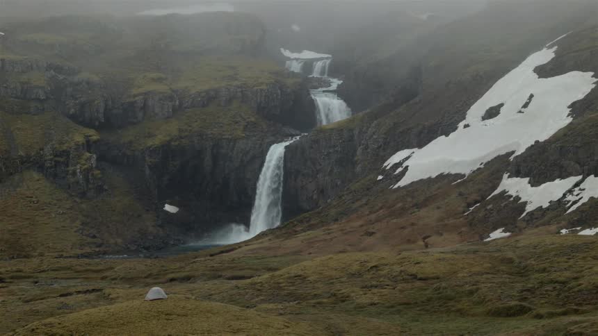 A stream drops off into different waterfalls over a mountain