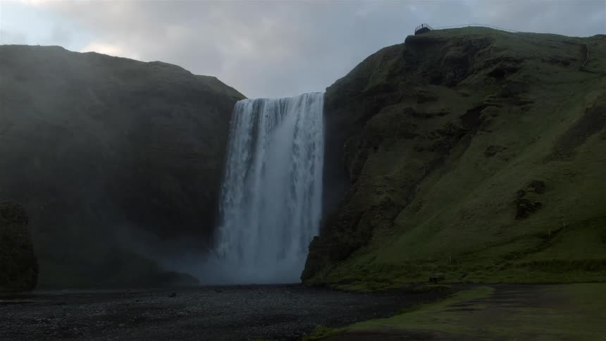 Clouds are above this large waterfall