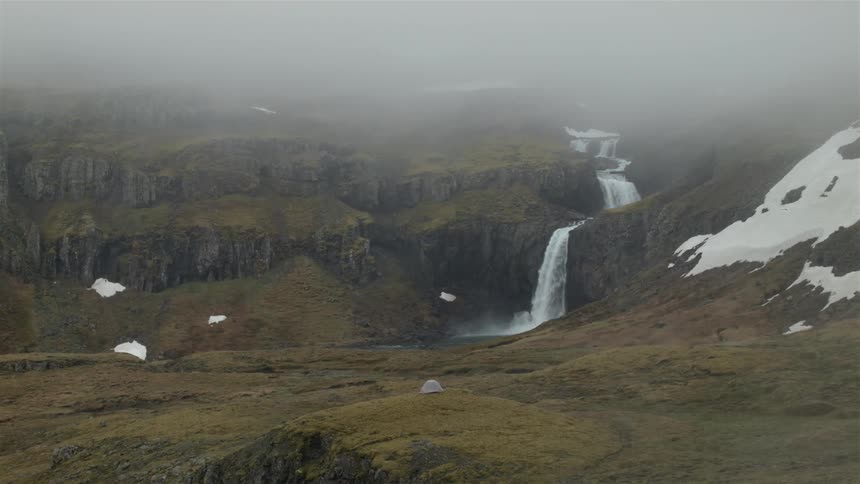 Waterfall flowing in a grassy area