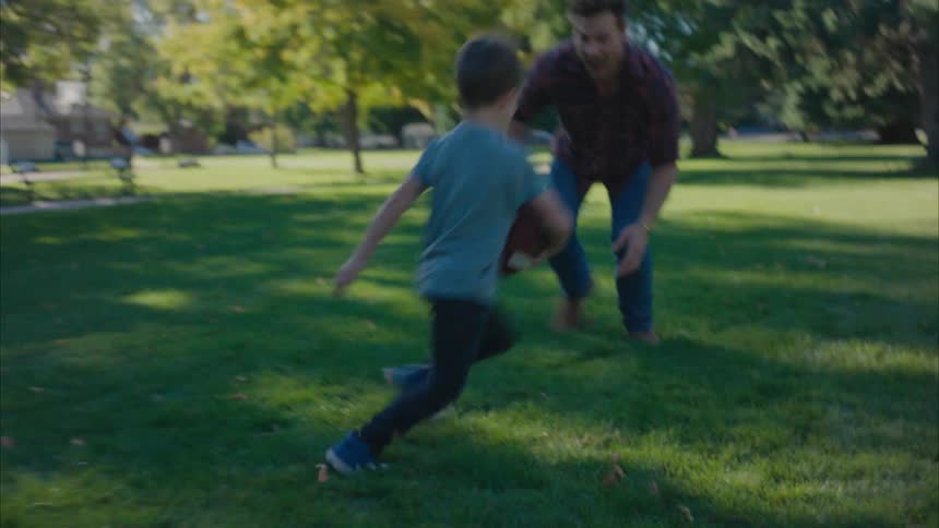 Father and son playing in a neighborhood park outdoors