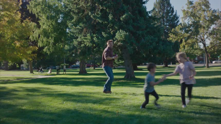 A family are playing football in the park