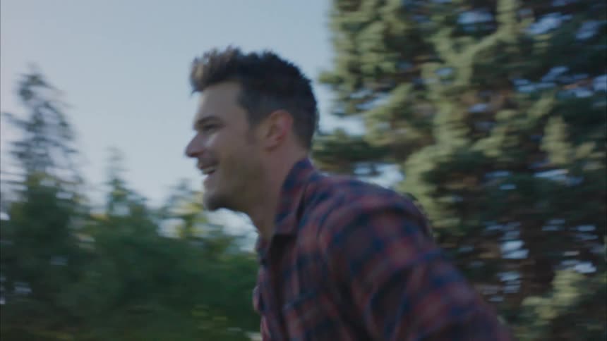 Portrait of a smiling man chatting and moving in a park