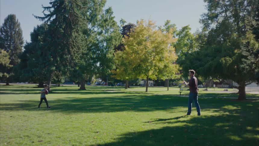 Father playing football with his son in the park