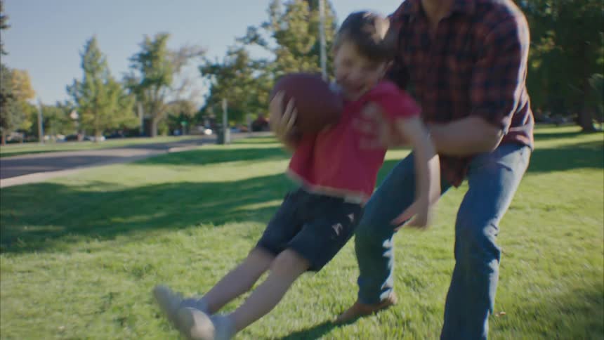 Father and son playing in a park on a sunny day