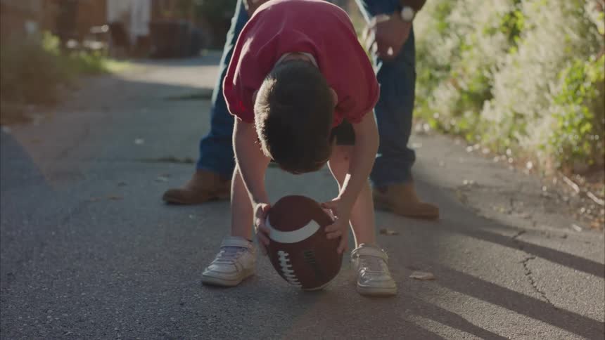 Father playing football with his sons in the yard
