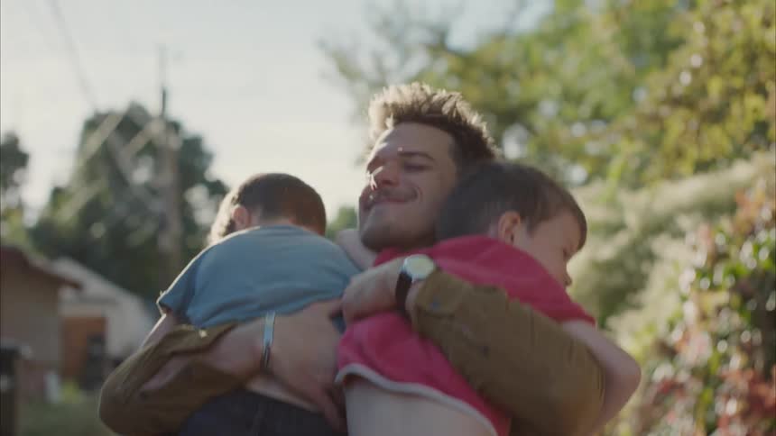 Father hugs his sons in the backyard at morning