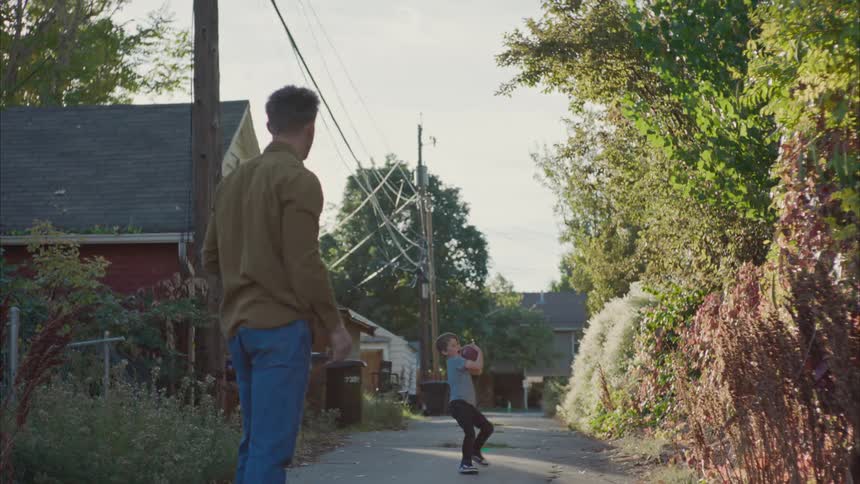 Father picking up his son while playing american football