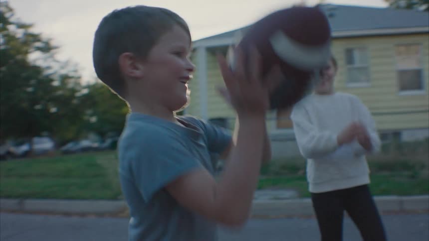 Father playing football with his children in the street