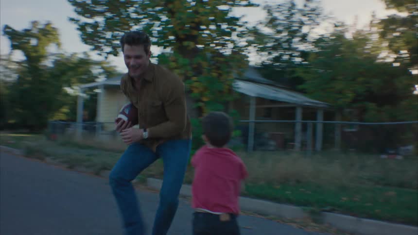 Father playing american football with his children on the street
