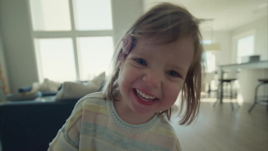 A little girl smiling very happily at the camera