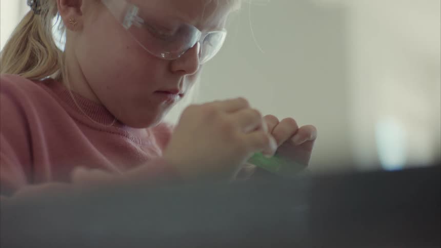 Face of a girl with protective glasses observing a software component