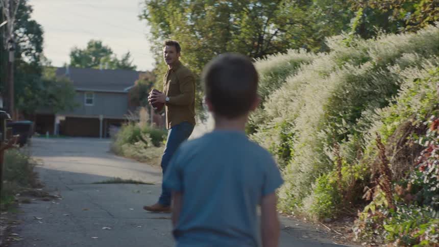 Father playing football with his son in the yard