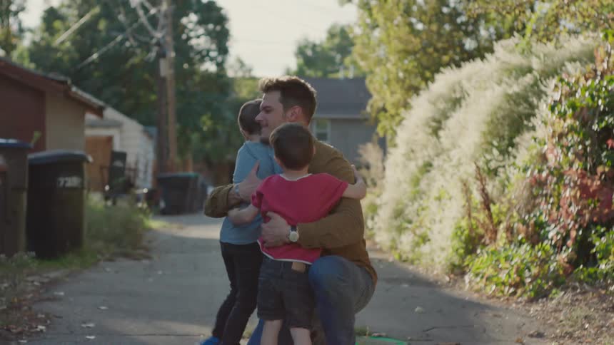 A father playing with his sons outside the house