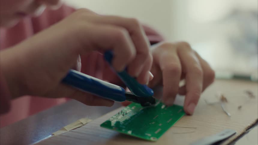 Girl wearing protective goggles working on electronics