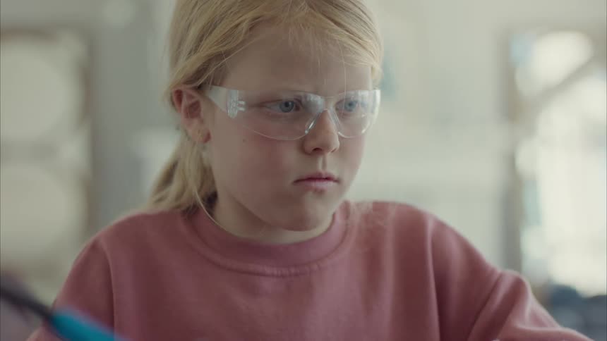 Portrait of a girl with protective glasses examining hardware