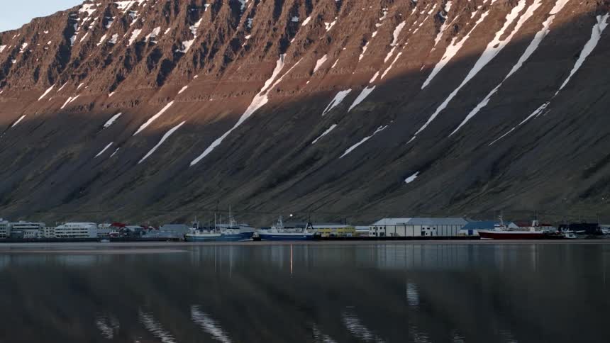 View of a bayside village at the foot of the mountains