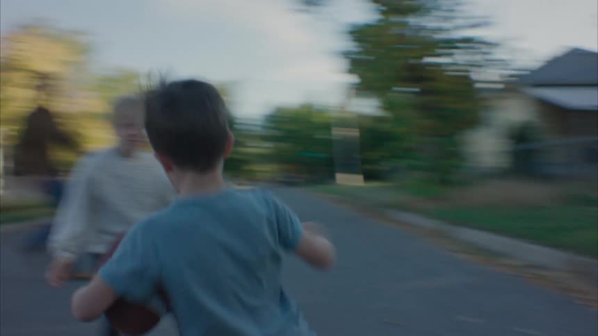 Family playing football in the street at morning