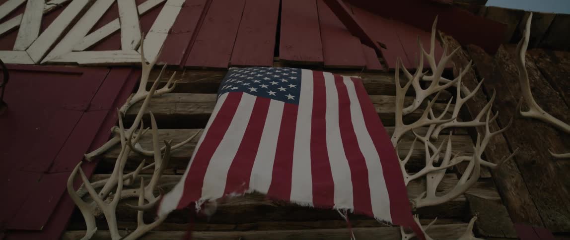 American flag waving on the wall of a barn