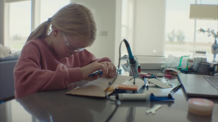 A girl doing a school project at the table