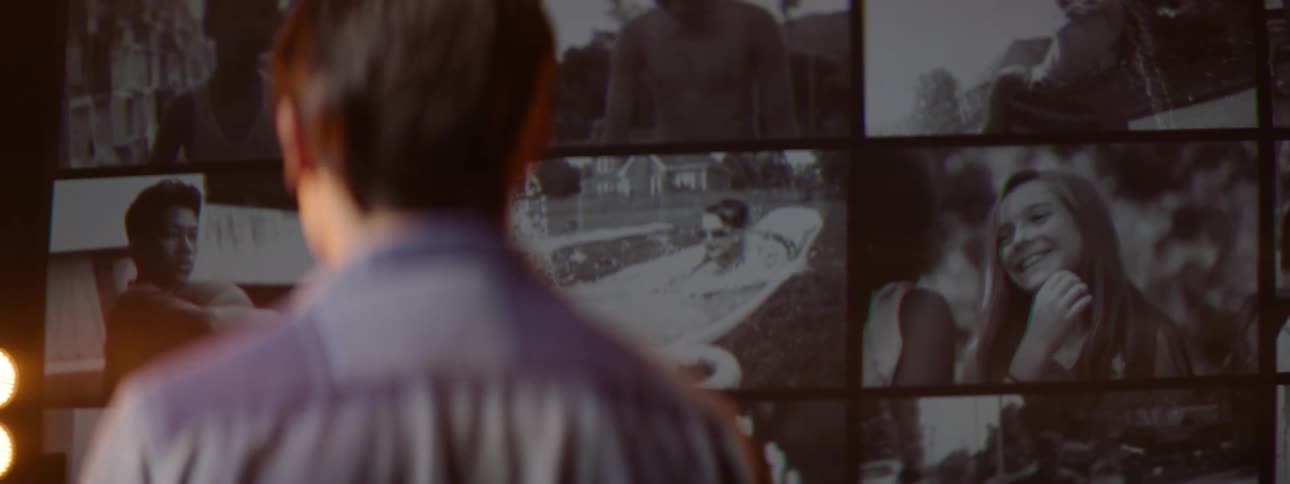 Boy looking at a screen with various frames of children in footage
