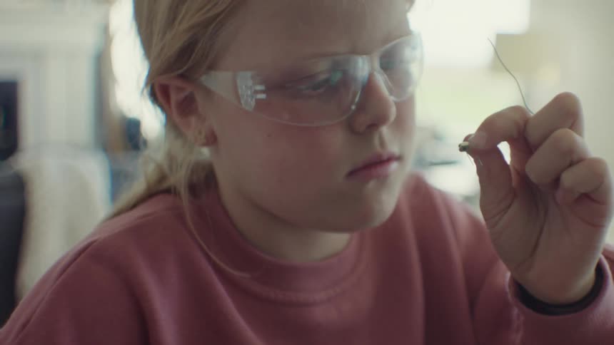 A child wearing clear glasses in a laboratory
