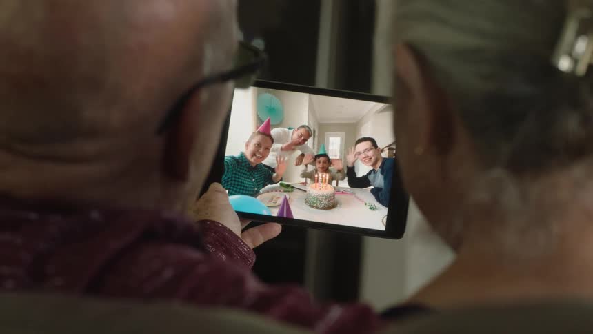 A family celebrate a birthday over a video call
