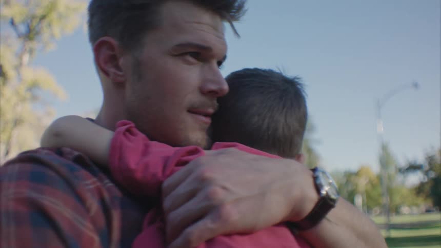 Portrait of a father holding his son in his arms and giving a hug