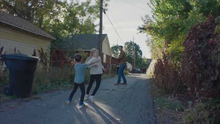Father plays with his kids in the back alley