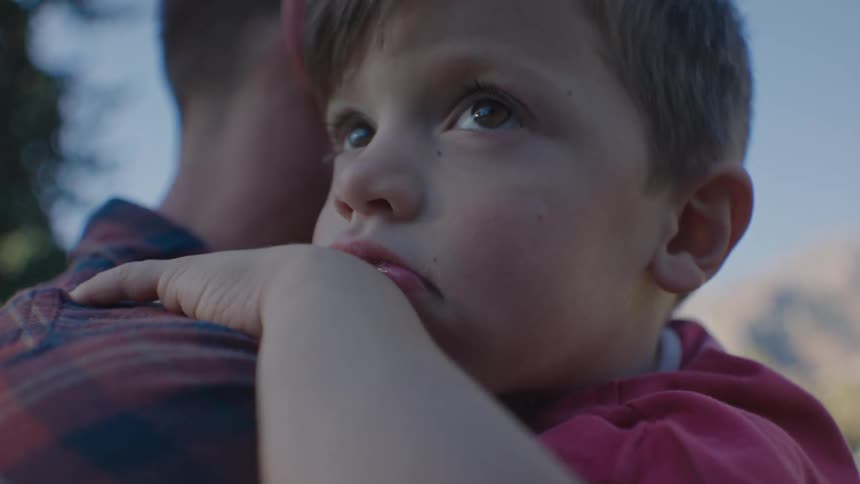 Boy reclined on his father shoulder at morning